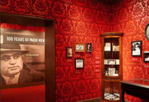 Exhibit at The Mob Museum in Las Vegas showcasing historical artifacts, including a display titled '100 Years of Made Men' with photographs and memorabilia from organized crime history.