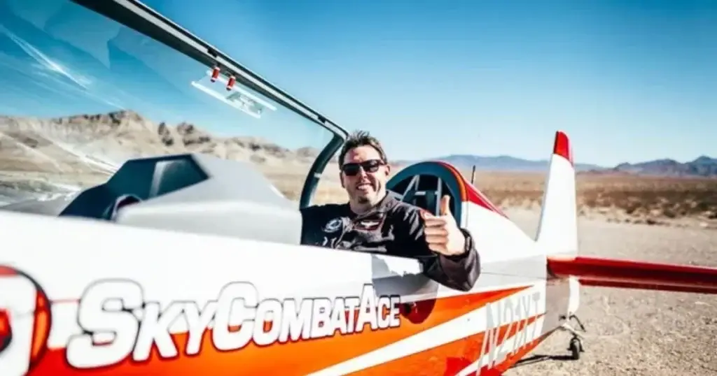 Excited pilot giving a thumbs up while sitting in a Sky Combat Ace aircraft on a desert airstrip, ready for an adrenaline-pumping aerial adventure over the Las Vegas landscape.